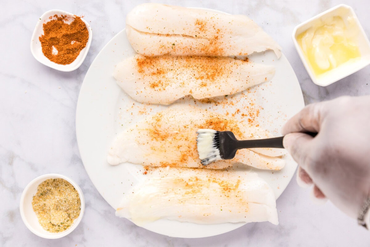 brushing softened butter onto orange roughy filets