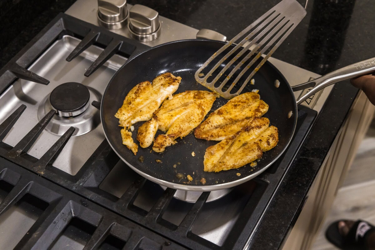 fish turner spatula flipping fish filets in a skillet
