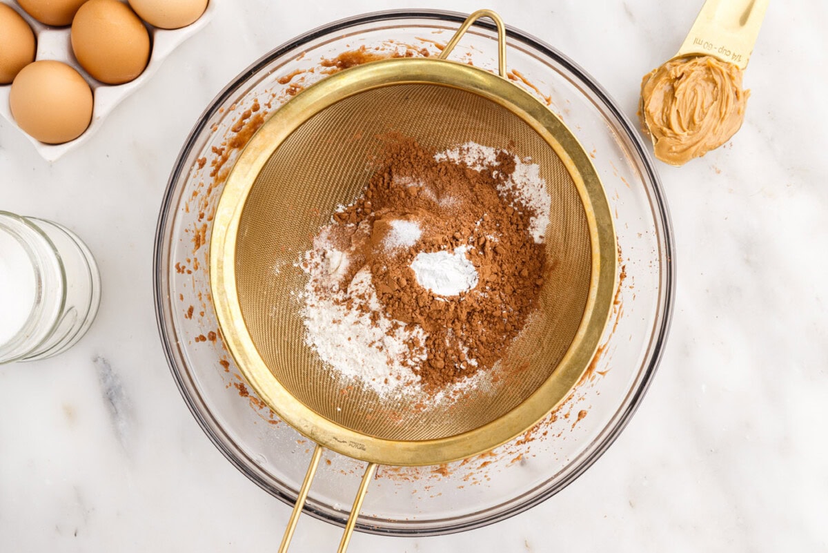 sifting brownie dry ingredients in a bowl