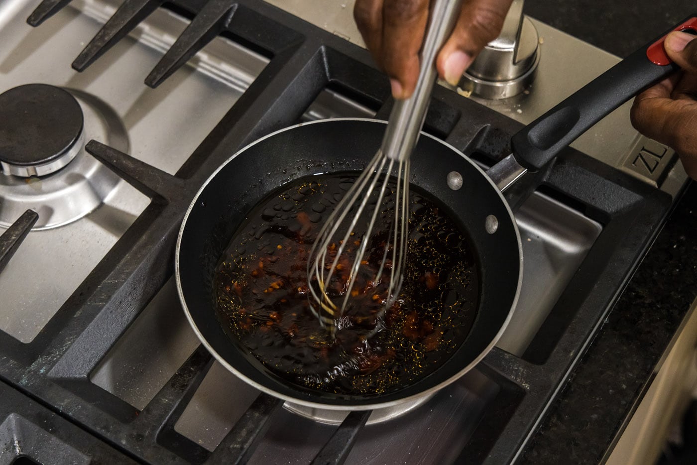 whisking sauce in a skillet