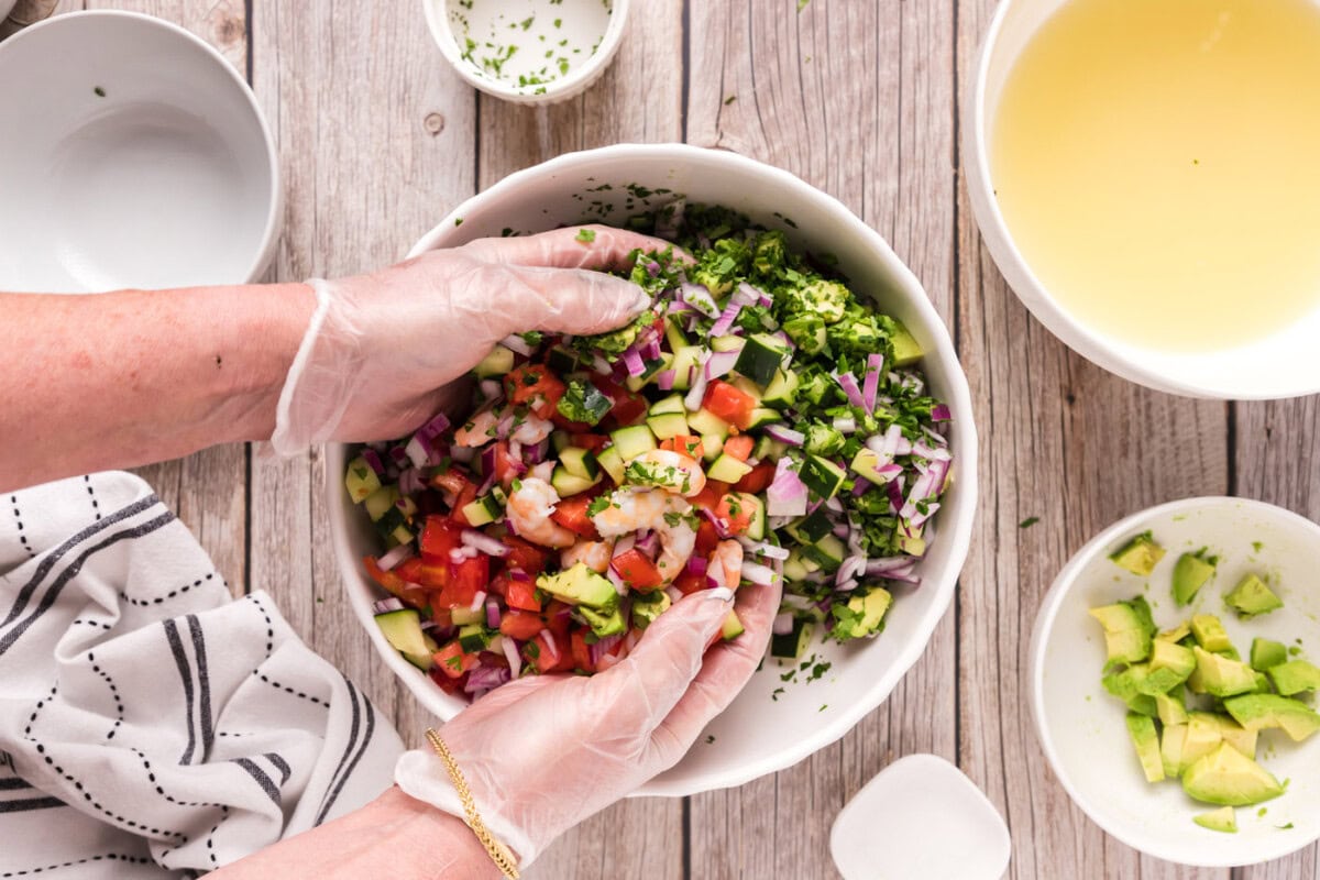 tossing shrimp ceviche in a bowl