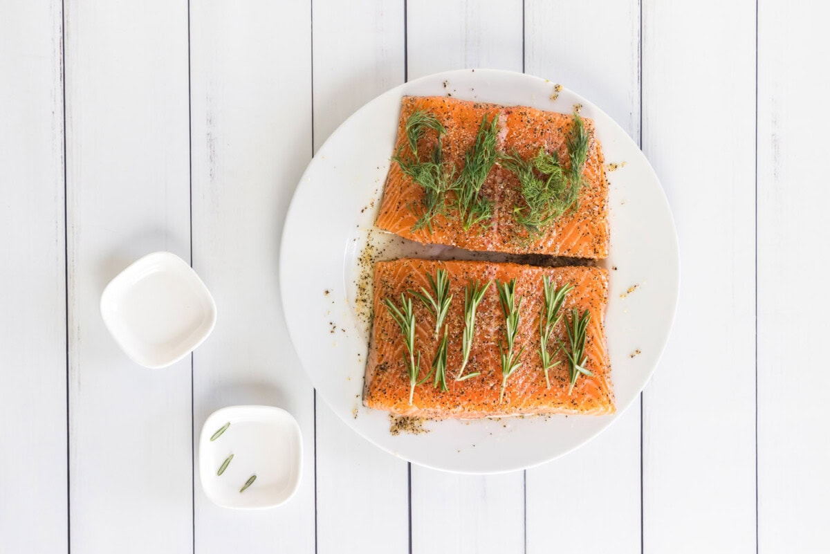 fresh herbs on top of salmon filets