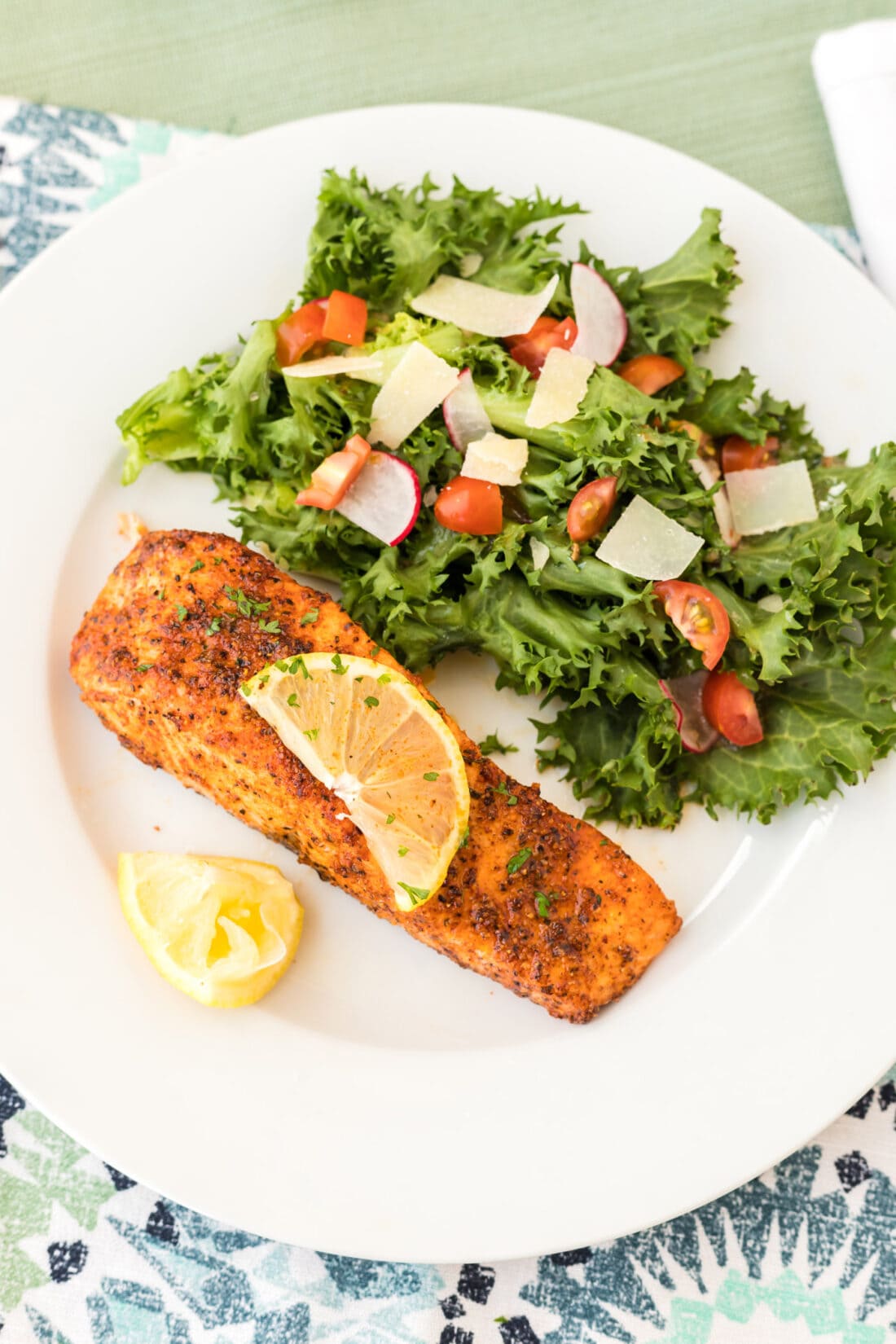 Air Fryer Salmon on a plate with a side salad