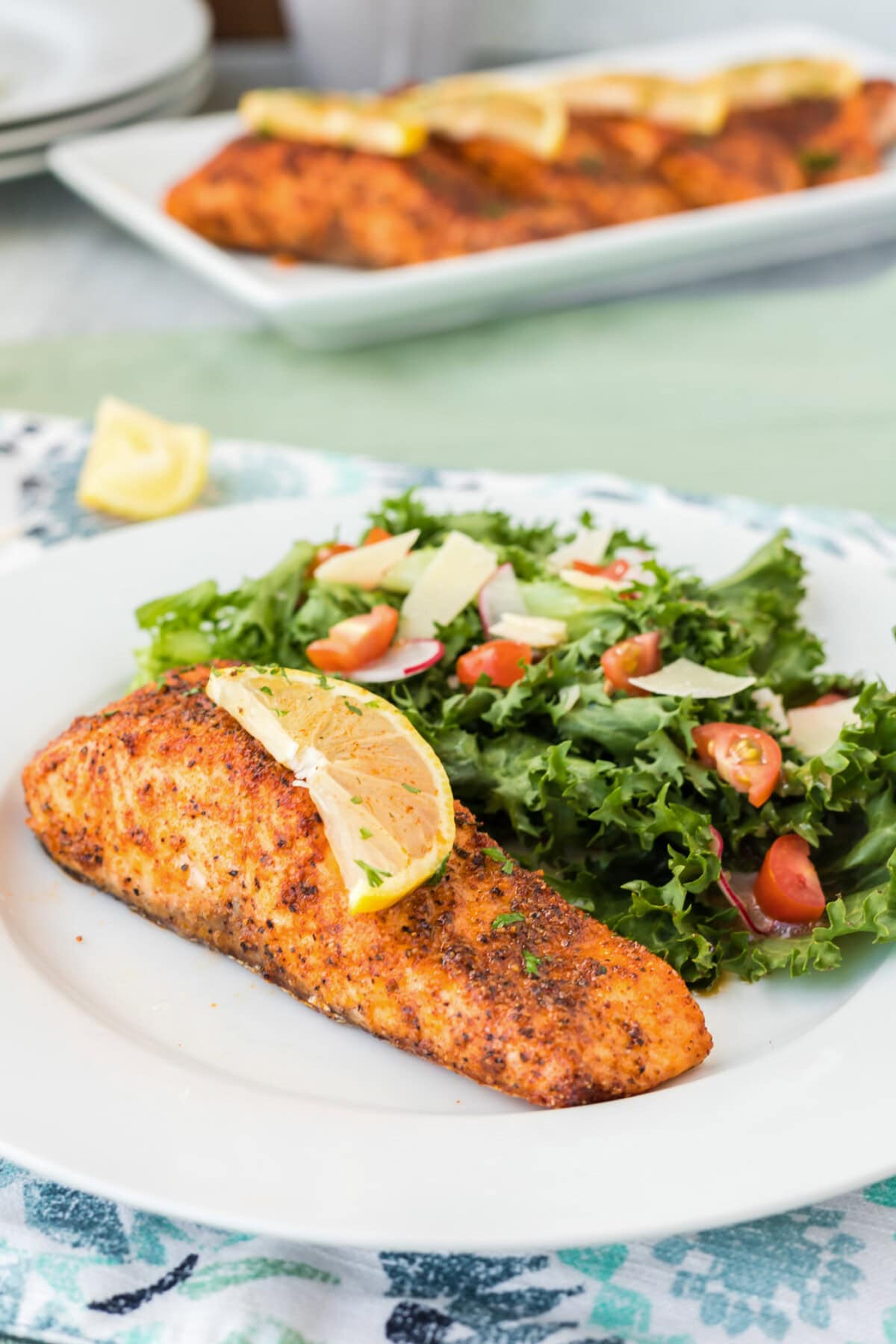 Air Fryer Salmon on a plate with a slice of lemon on top