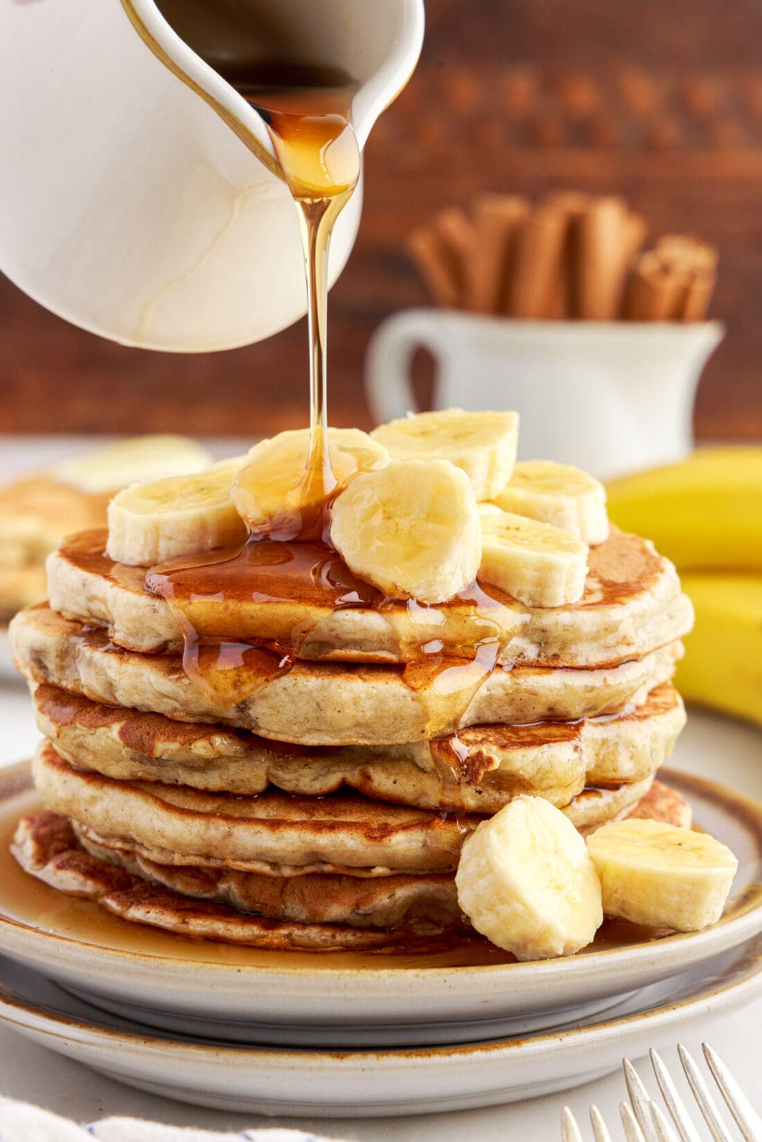 Stack of Banana Pancakes with syrup being poured on top