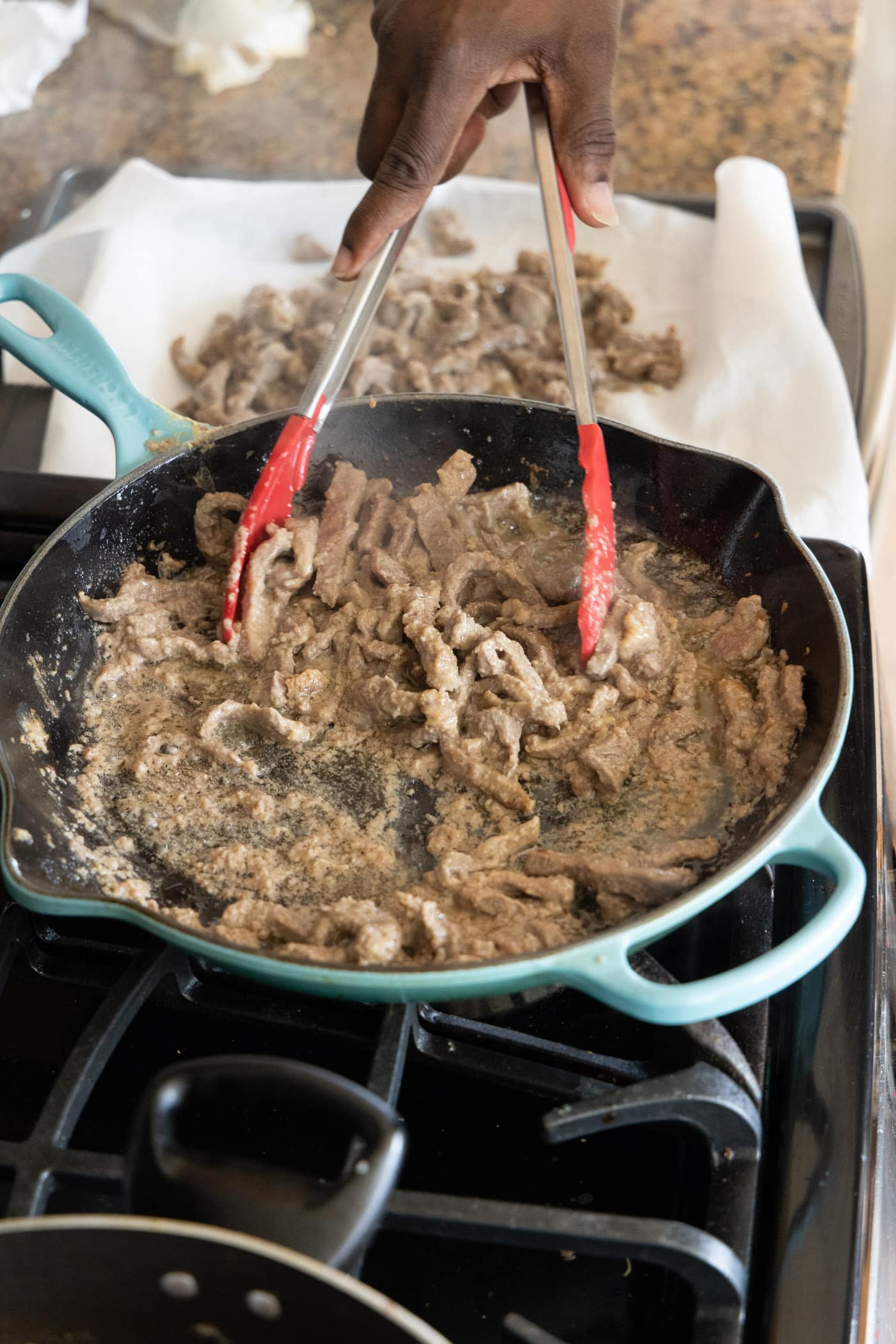 removing cooked beef from skillet