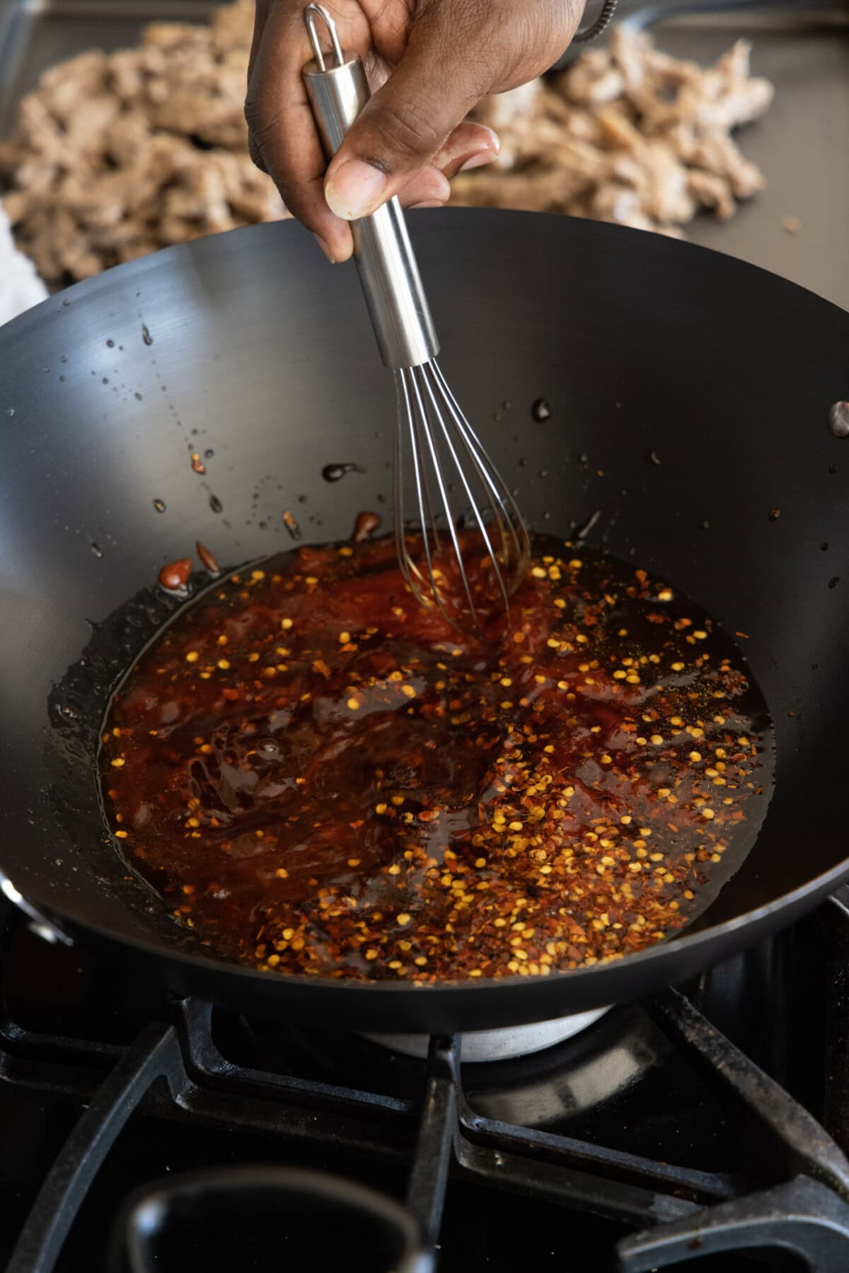 whisking beijing beef sauce in a wok