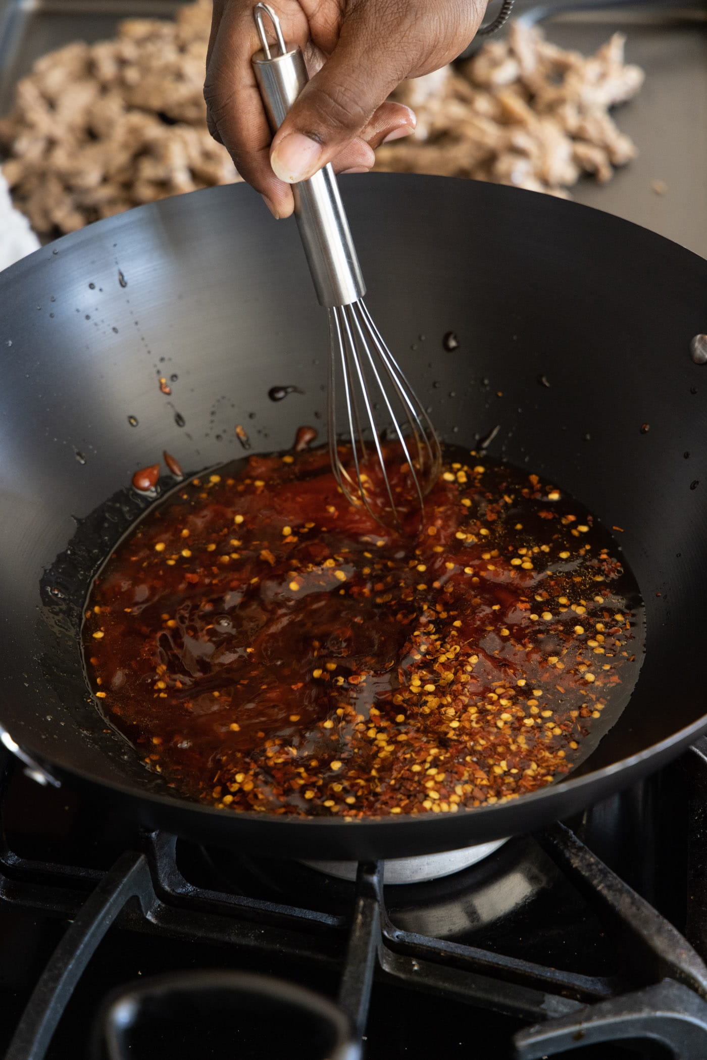 whisking beijing beef sauce in a wok