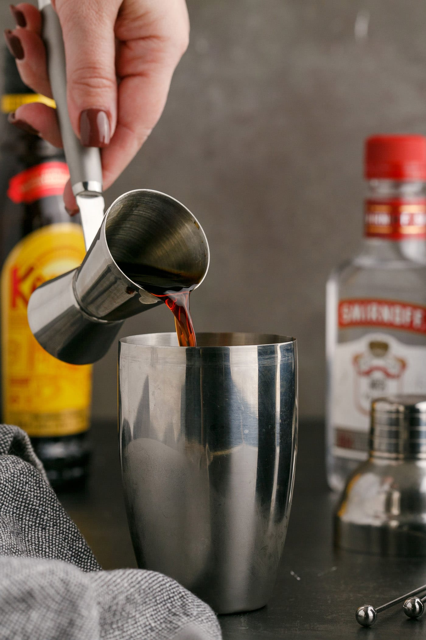 pouring Kahlua into cocktail shaker
