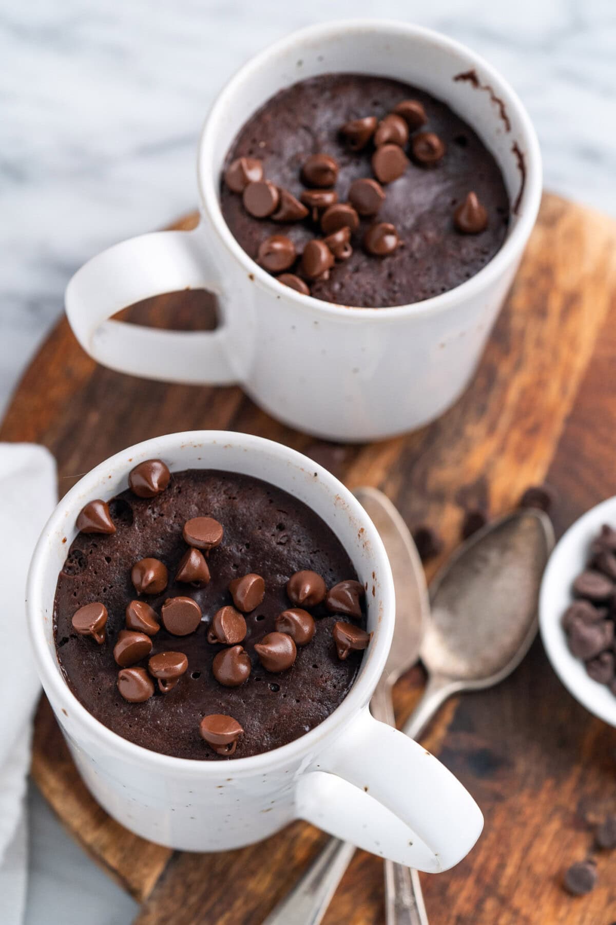 Two servings of Brownie in a Mug on a wooden platter