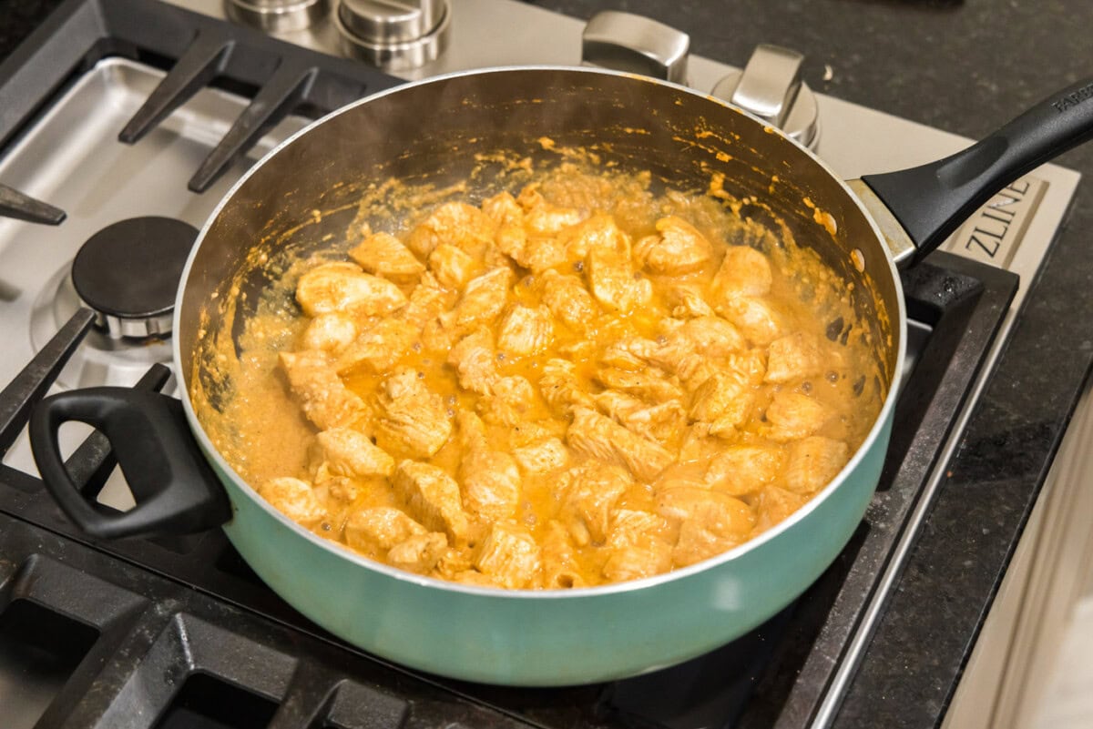 cooking chicken tikka masala in a skillet