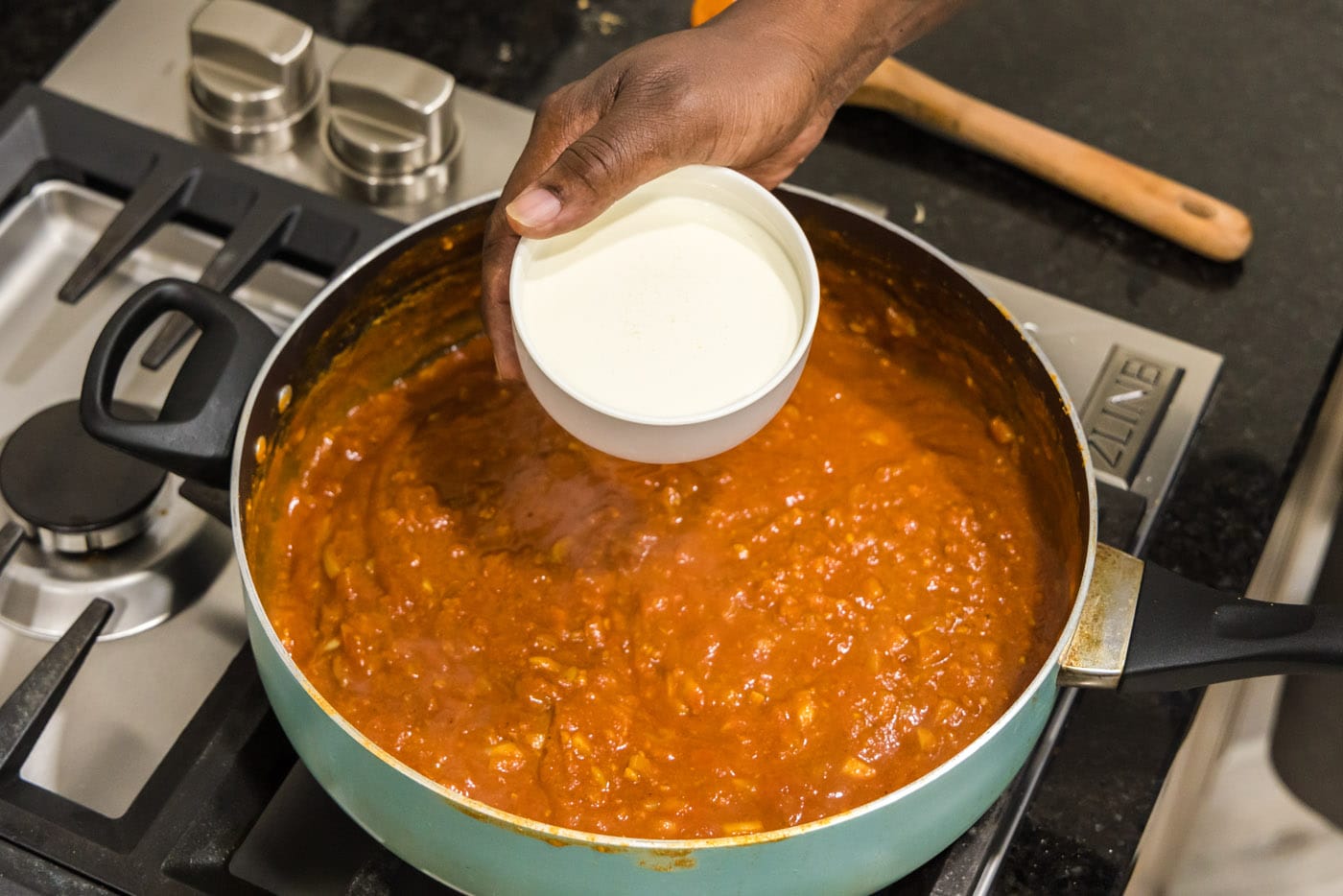 adding cream to tomato sauce for chicken tikka masala