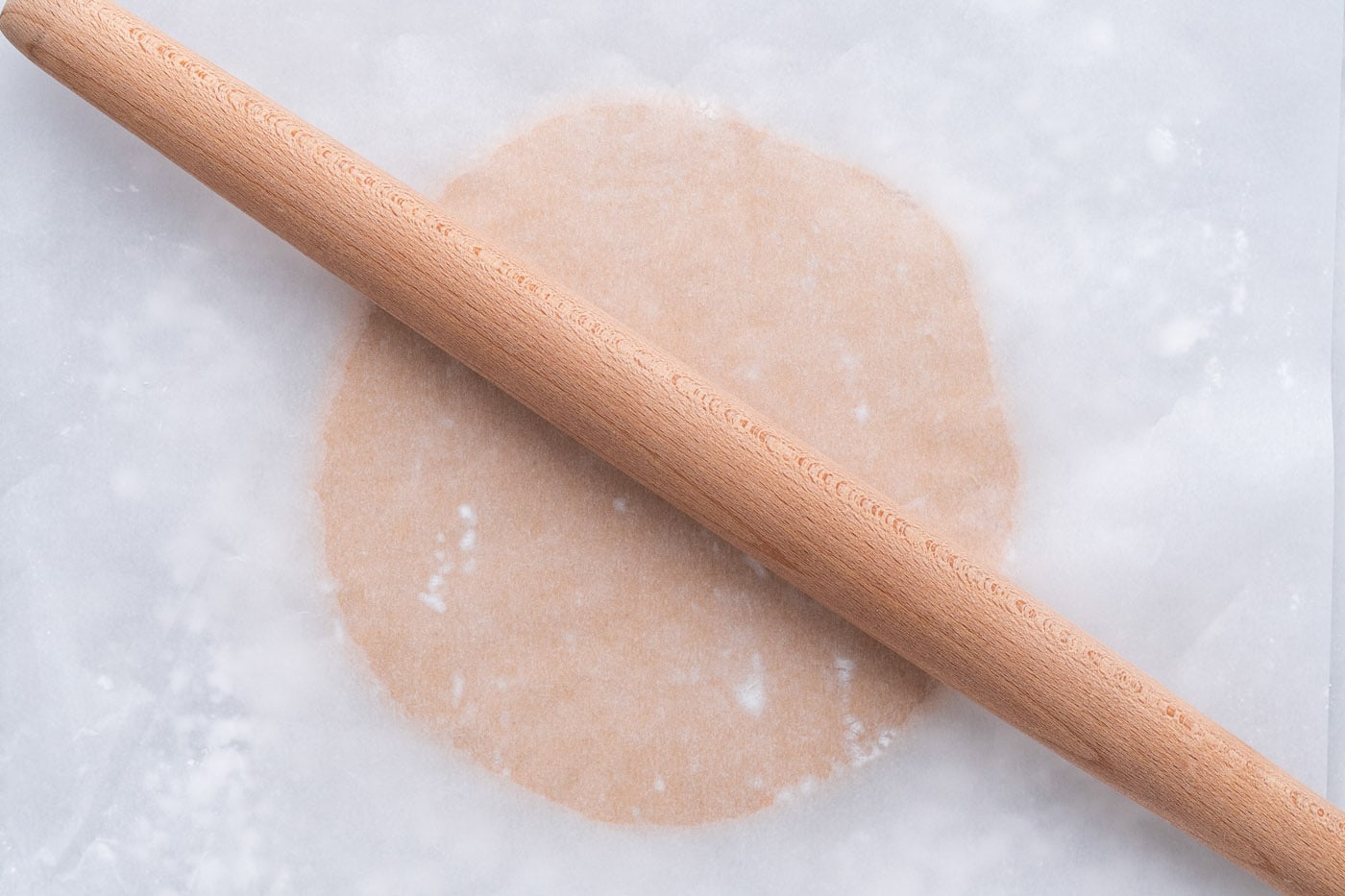rolling the peanut butter dough ball with a rolling pin
