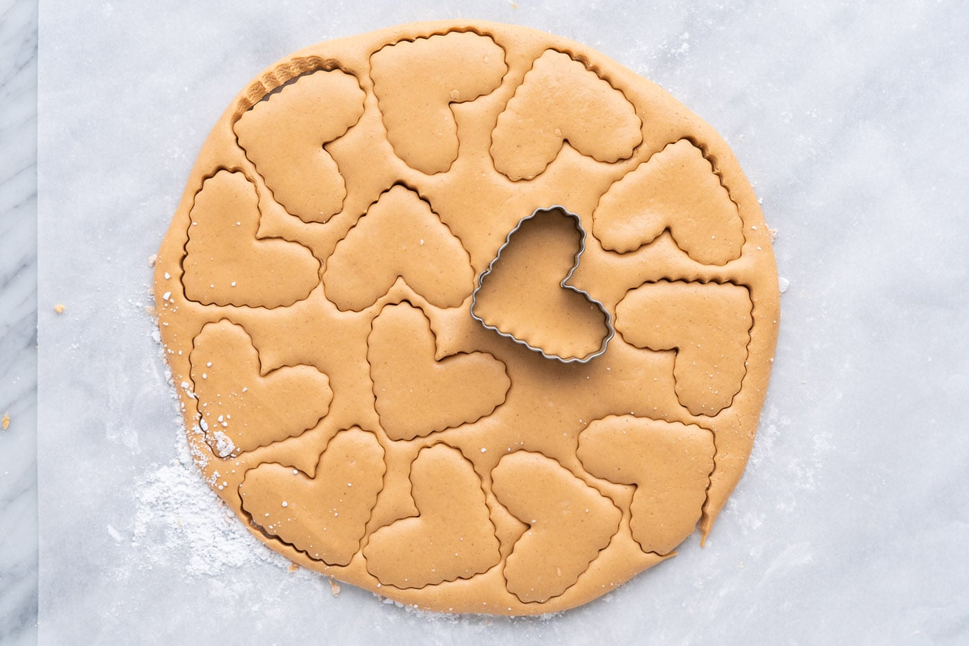 stamping hearts with a cookie cutter into peanut butter dough