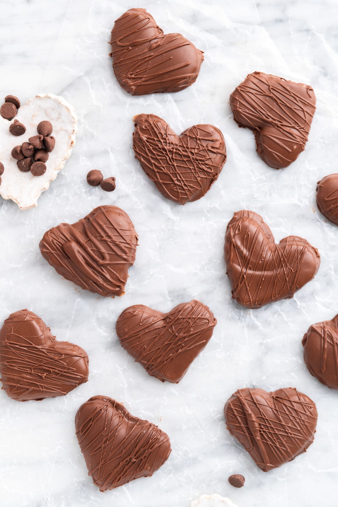 Chocolate Peanut Butter Hearts on a piece of parchment paper with chocolate chips