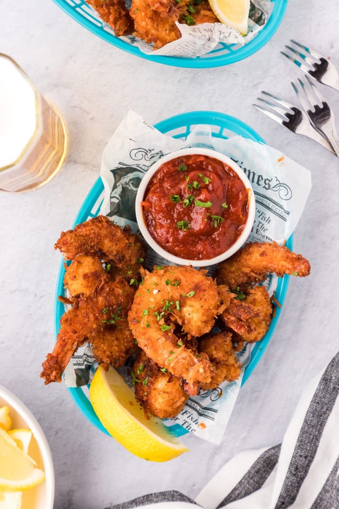 Coconut Shrimp in a basket with a bowl of cocktail sauce