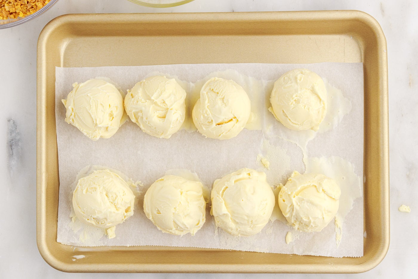 ice cream balls on parchment lined baking sheet
