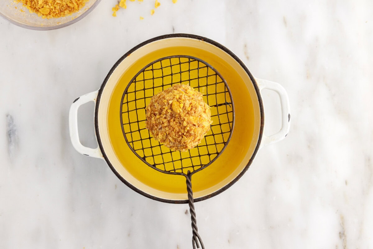dipping cornflake coated ice cream into oil
