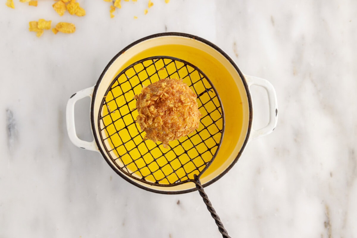 lifting fried ice cream ball from oil