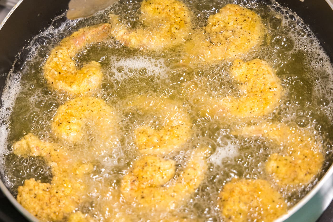 fried shrimp cooked in oil on the stovetop