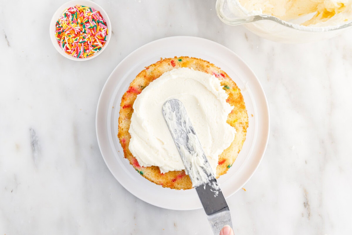 spreading frosting over cake layer