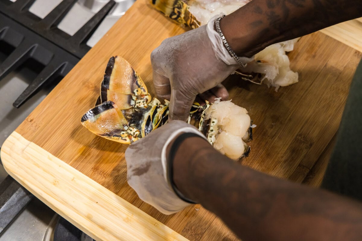 Hands cracking the underbelly of a lobster shell