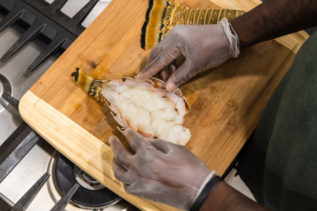breaking open lobster tail to expose the meat