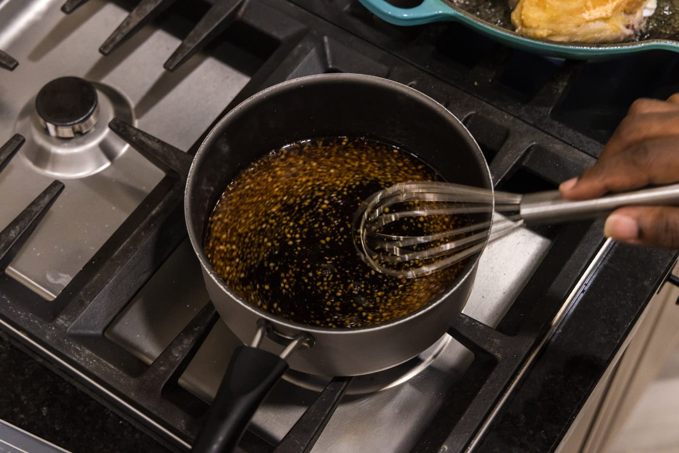 whisking honey garlic sauce in a saucepan