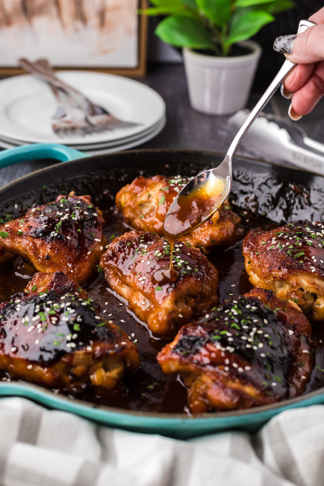 Honey Garlic Chicken in a skillet with sauce being drizzled over the chicken