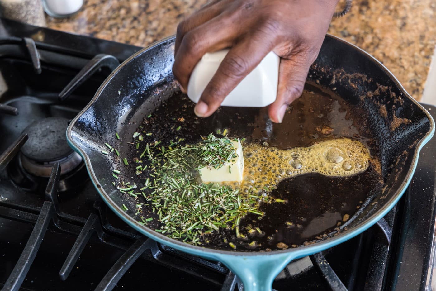 adding butter and rosemary to skillet