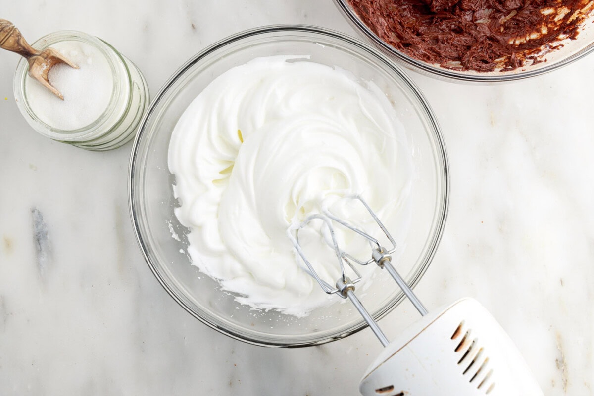 whipped egg whites in a mixing bowl using a hand mixer