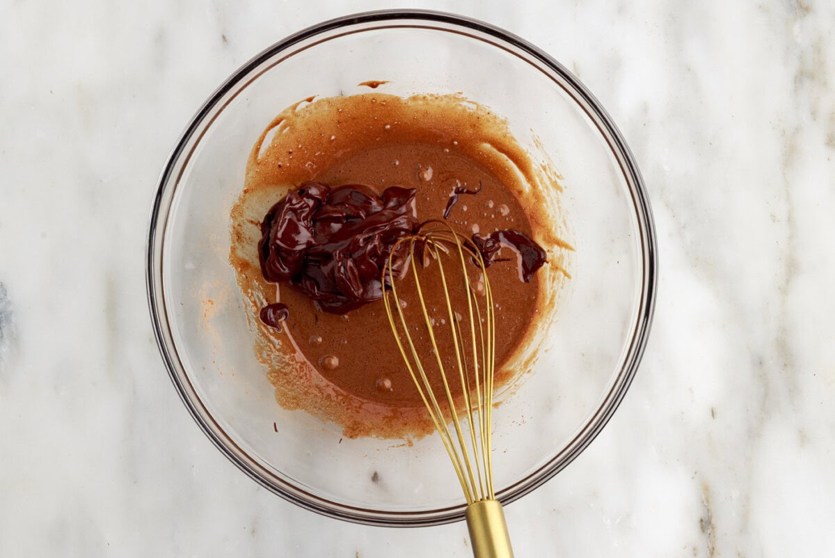 whisking batter and chocolate mixture in a bowl