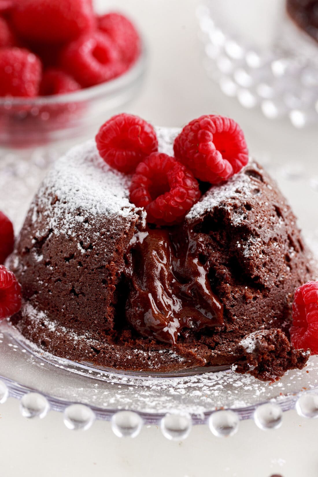 Lava Cake on a plate topped with powdered sugar and raspberries