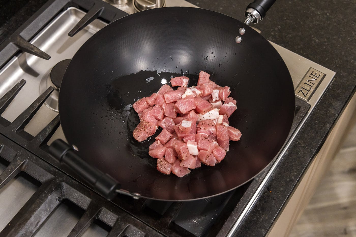 diced pork chops with oil in a wok