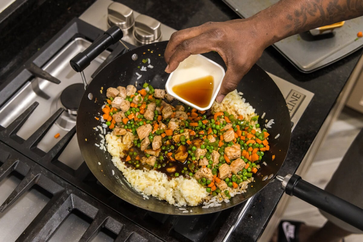 adding sesame oil to skillet with fried rice