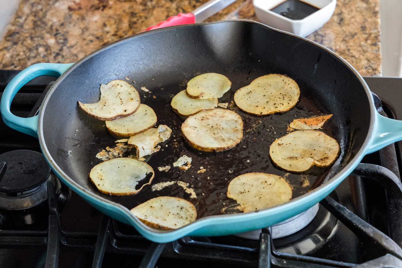 sliced potatoes in a skillet with oil