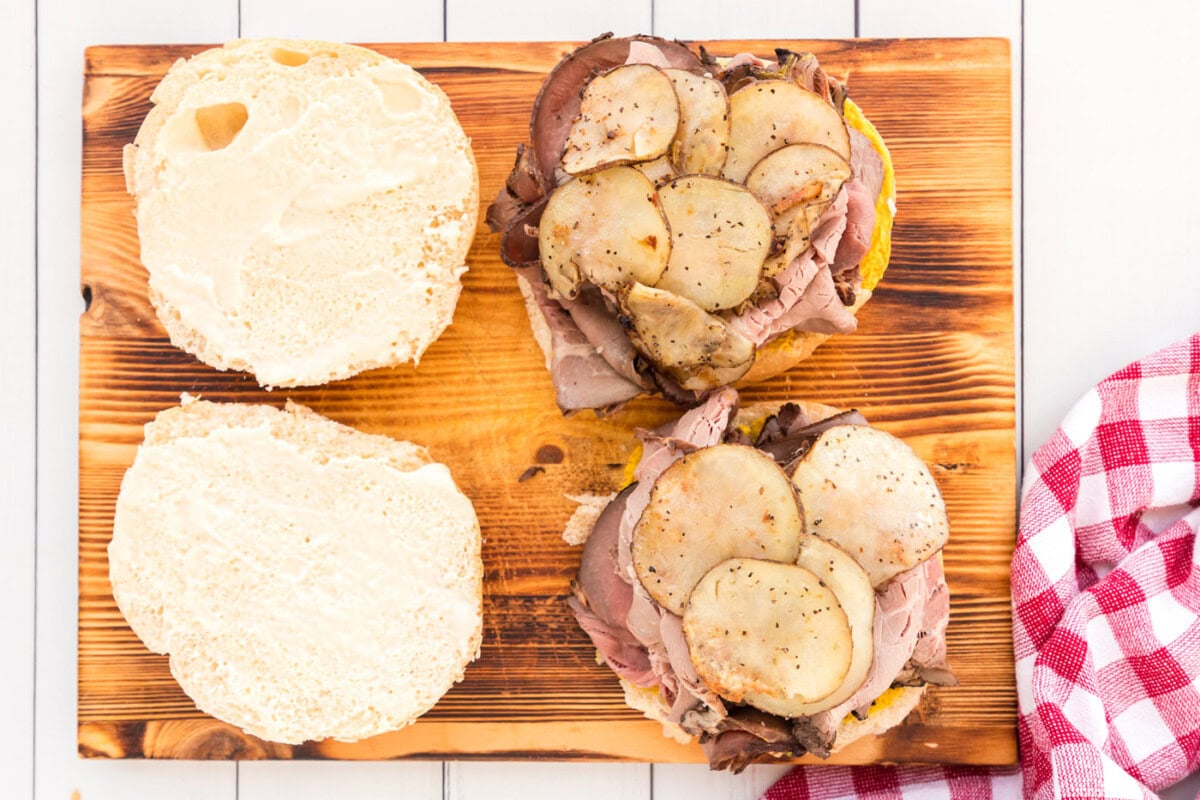 sliced potatoes on top of roast beef sandwich