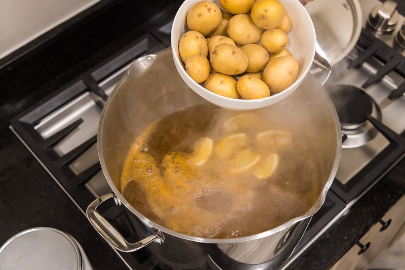 adding yukon gold babay potatoes to a pot of boiling water