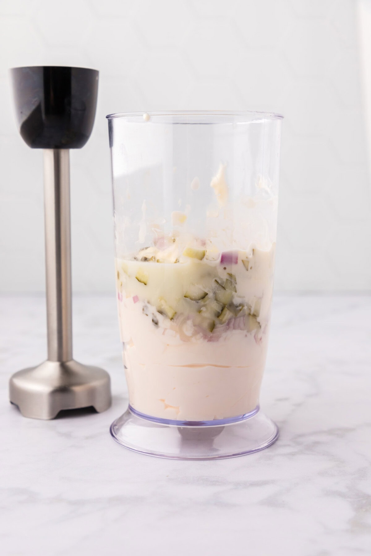 ingredients for tartar sauce in an immersion blender