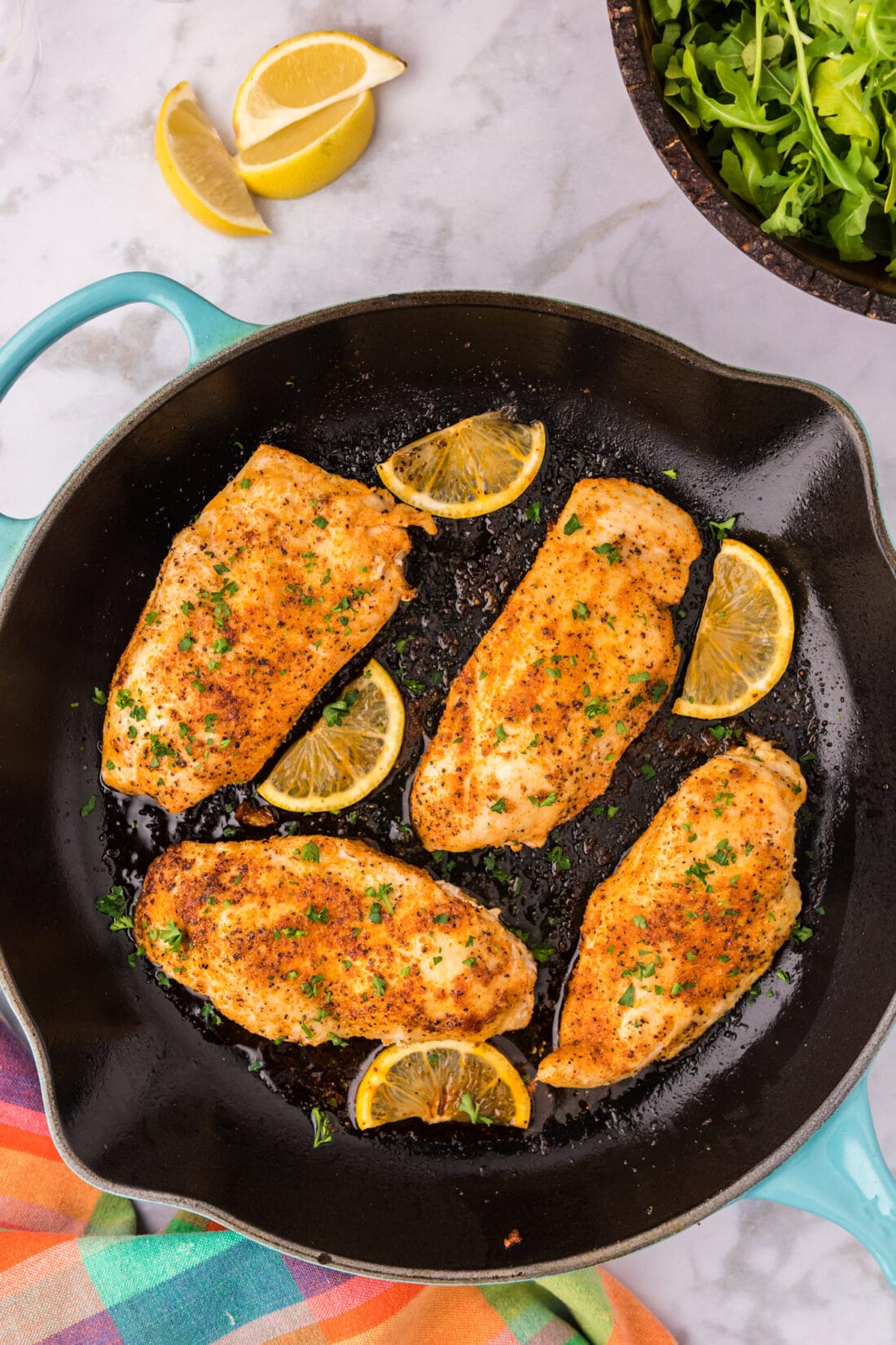 Blackened Chicken in a skillet with lemons
