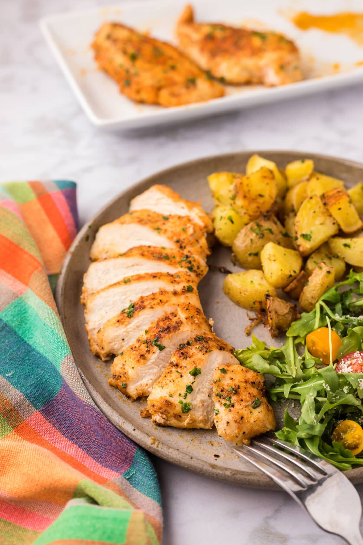 Blackened Chicken on a plate with a salad and potatoes