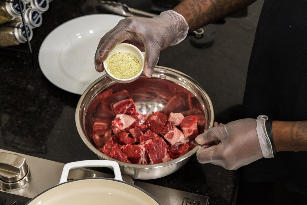 adding garlic salt to cubed chuck roast