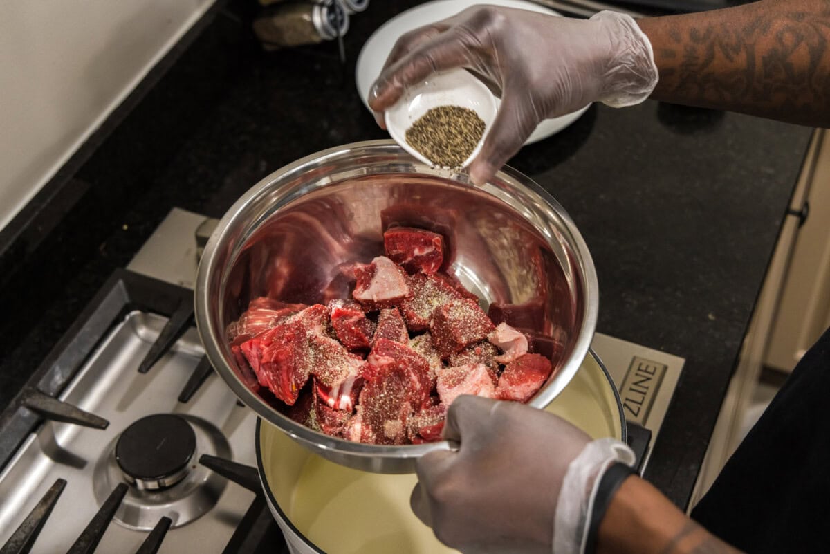 adding pepper to cubed chuck roast