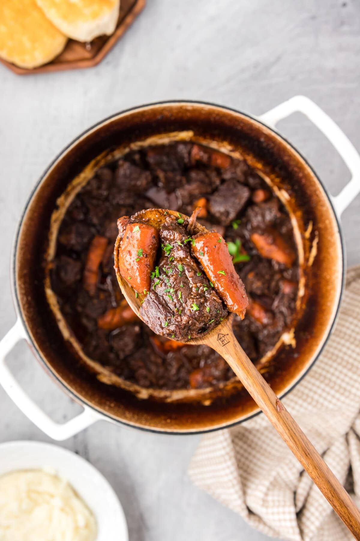 Spoonful of Braised Beef held over a pot of Braised Beef