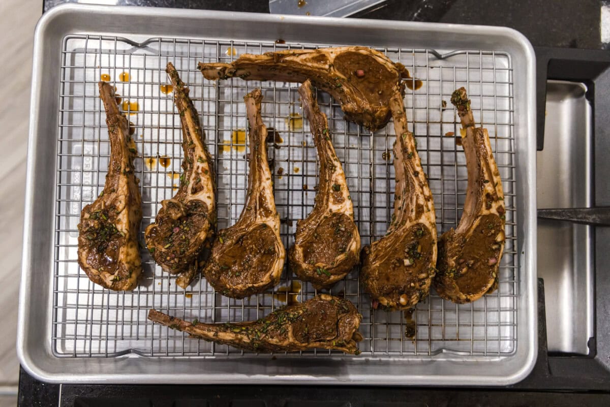 lamb chops on a wire rack over a baking sheet