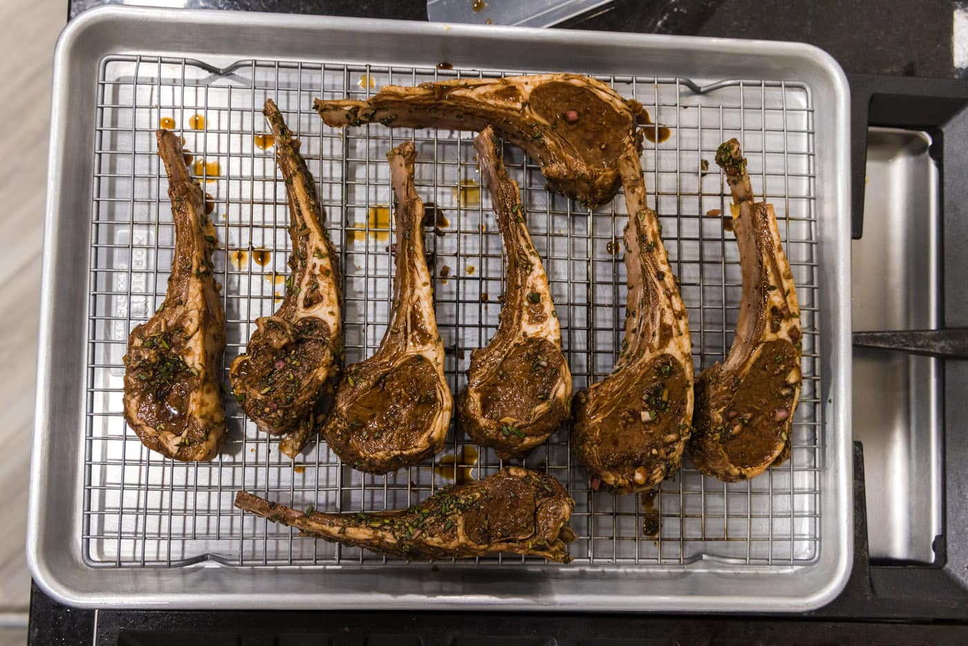 lamb chops on a wire rack over a baking sheet