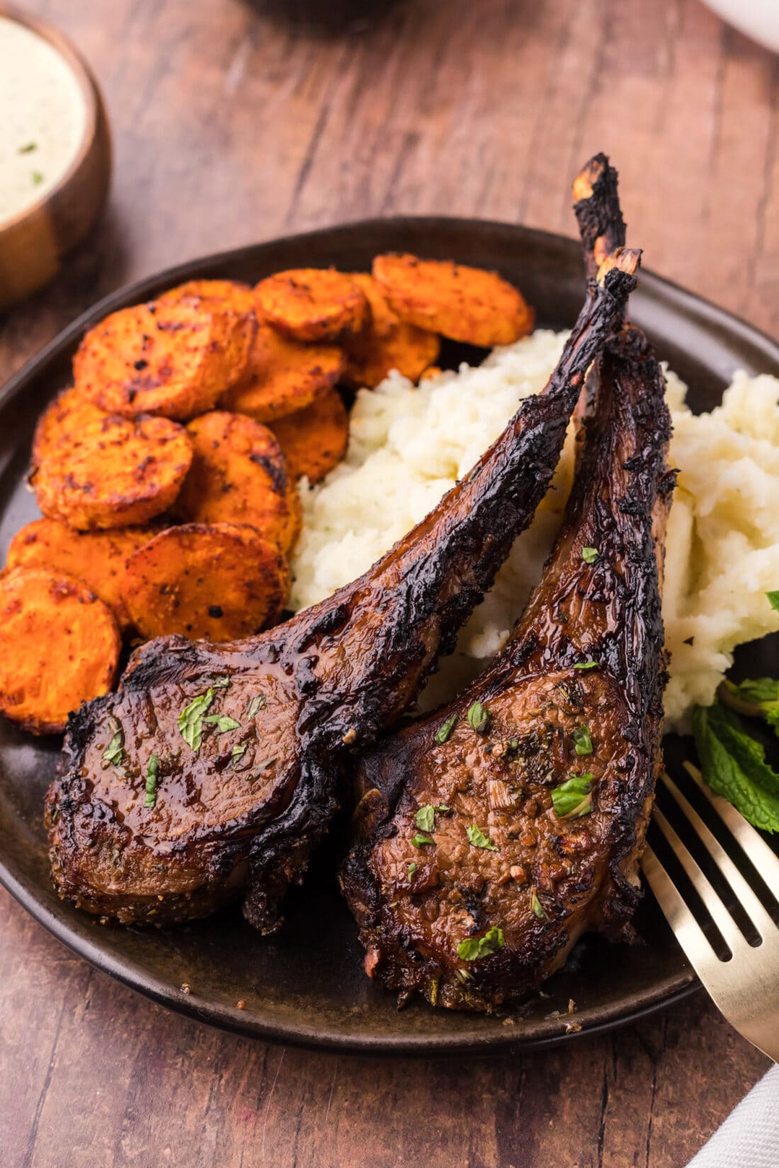 Two Broiled Lamb Chops on a plate with carrots and mashed potatoes
