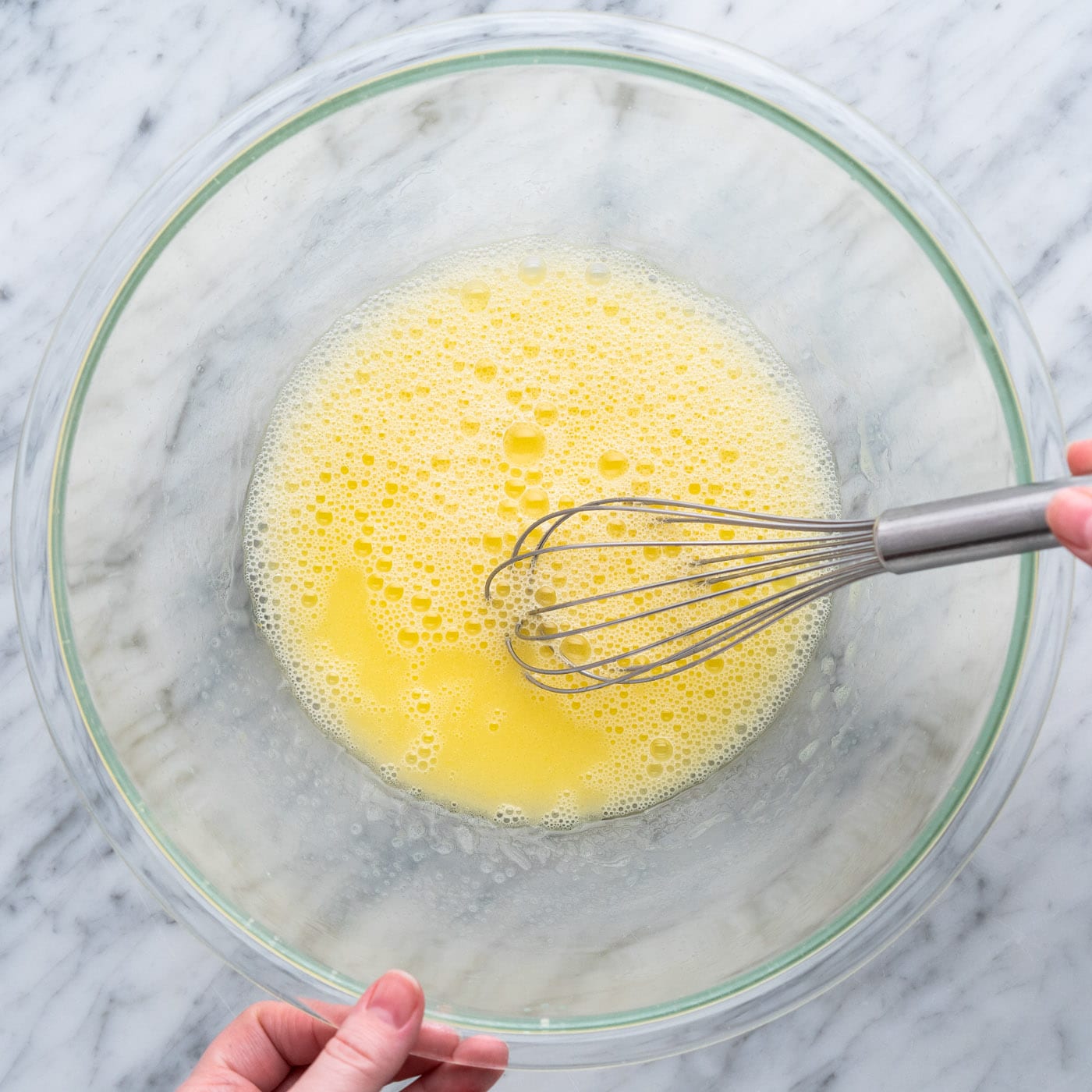 whisking egg, water, and oil in a bowl