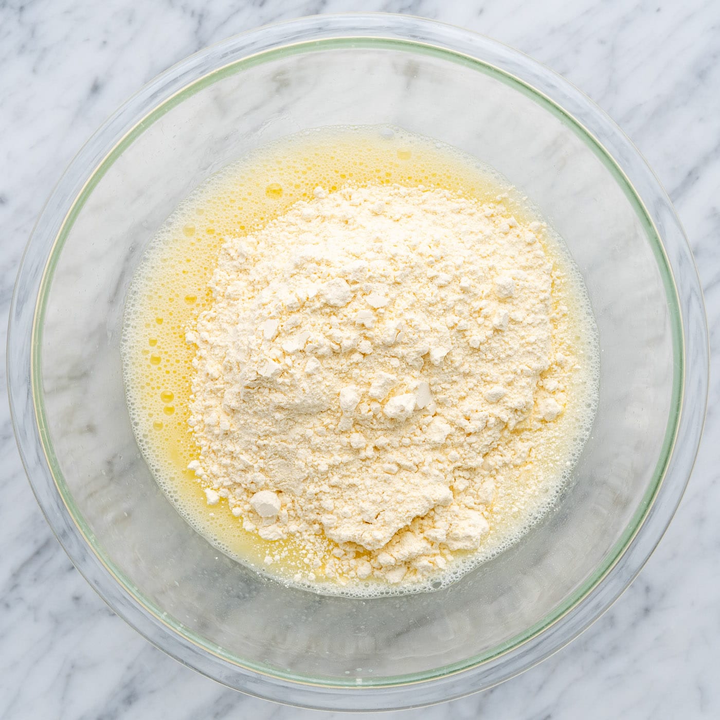 adding yellow cake mix to water, egg, and oil in a bowl