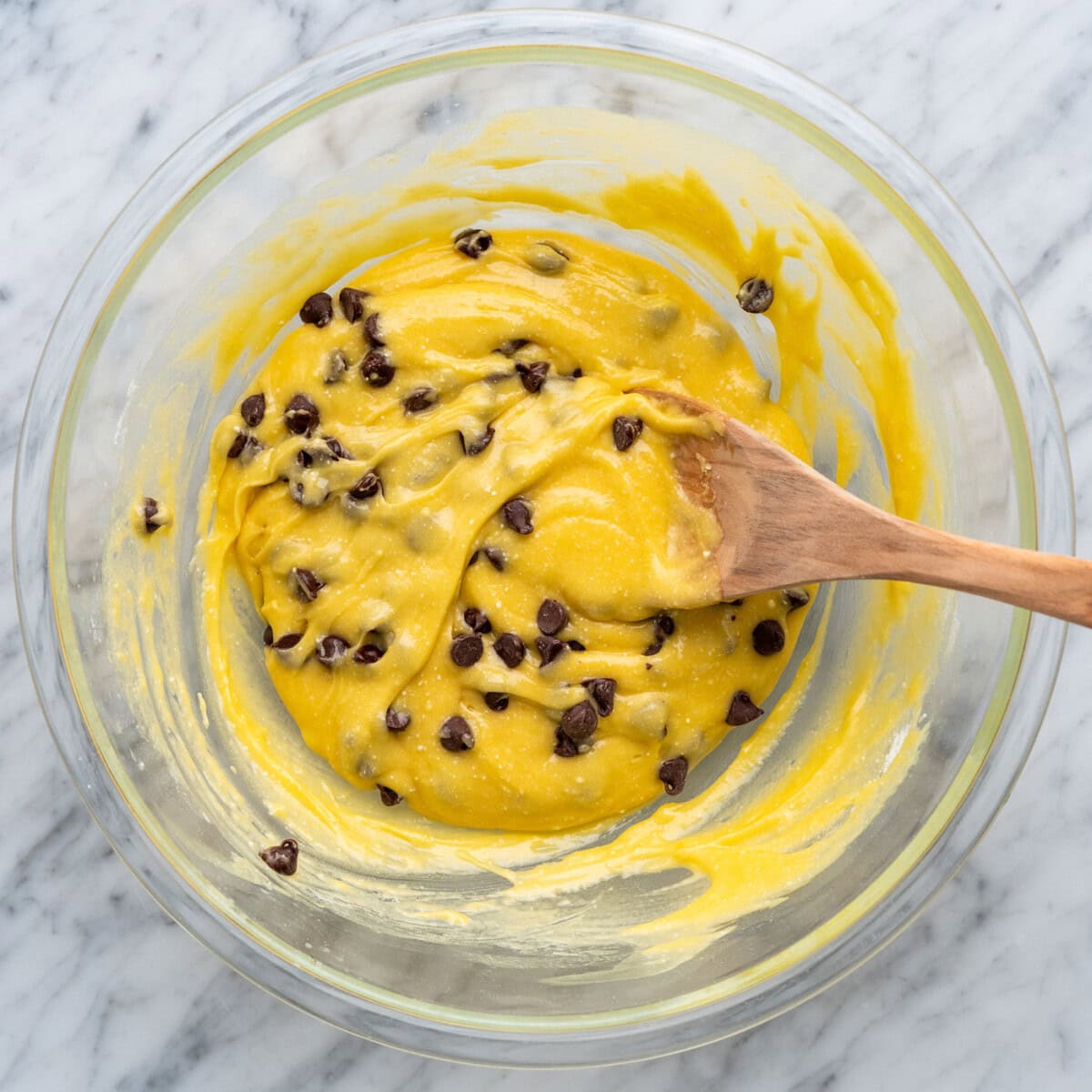 cake mix cookie bars mixed in a bowl with a wooden spoon